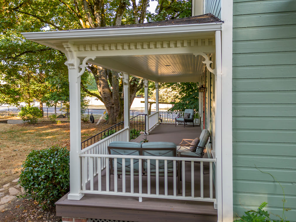 remodeled porch with white wood railing and green furniture in Salem, Oregon by Kraft Custom Construction 