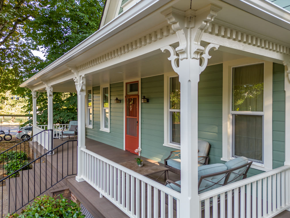 remodeled porch with white wood railing and green furniture in Salem, Oregon by Kraft Custom Construction 