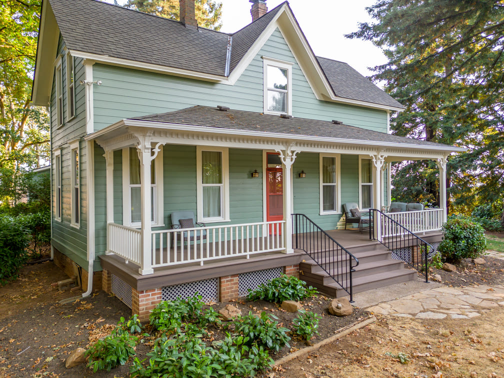 remodeled home with red door and green siding in Salem, Oregon by Kraft Custom Construction