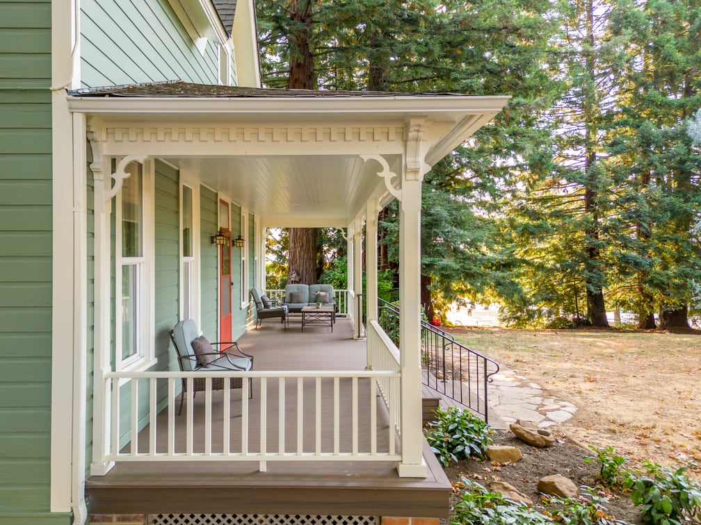 remodeled porch with white wood railing and green furniture in Salem, Oregon by Kraft Custom Construction 