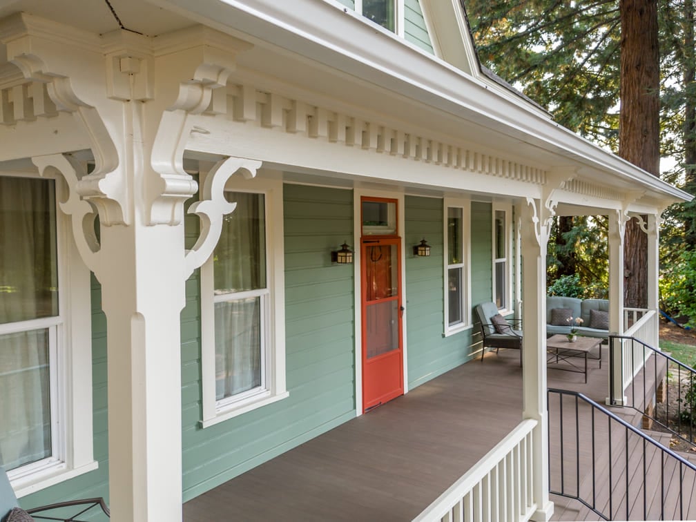 remodeled porch with white wood railing and green furniture in Salem, Oregon by Kraft Custom Construction 