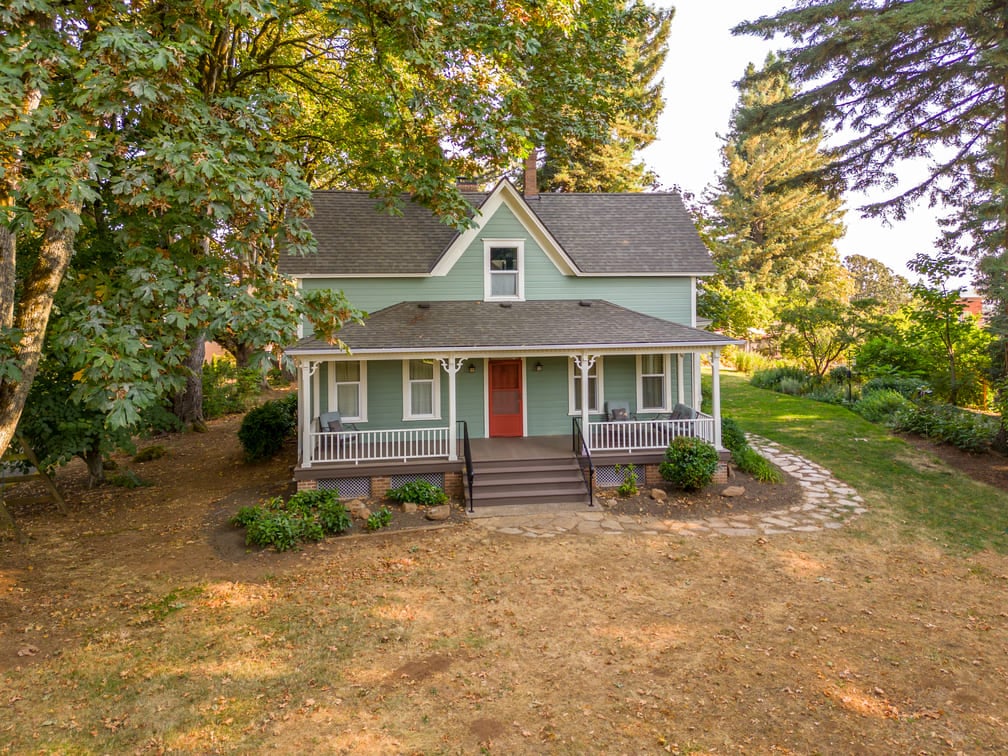 remodeled home with red door and green siding in salem, oregon by Kraft Custom Construction