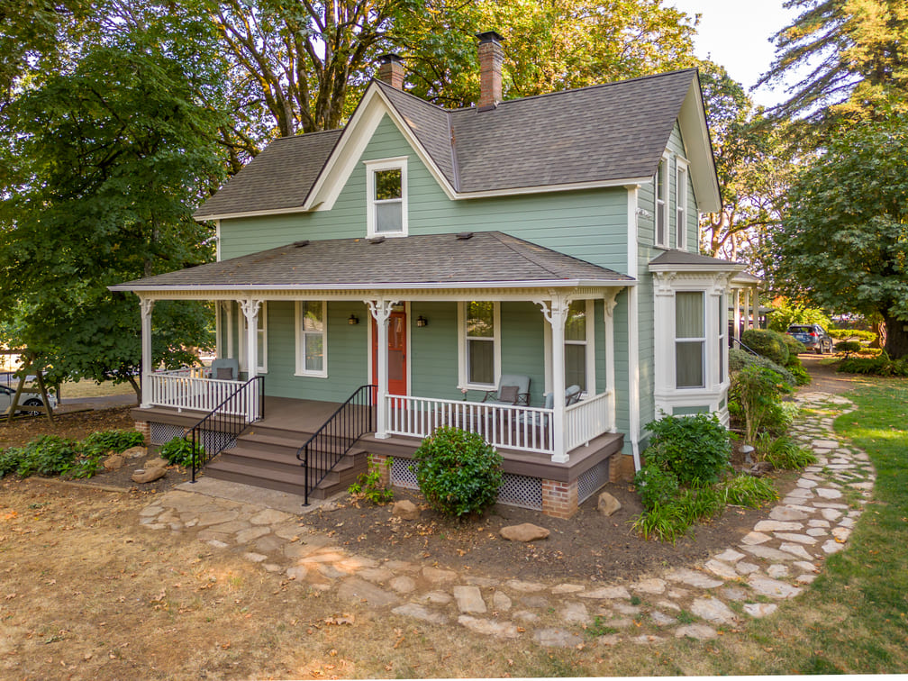 remodeled home with red door and green siding in Salem, Oregon by Kraft Custom Construction