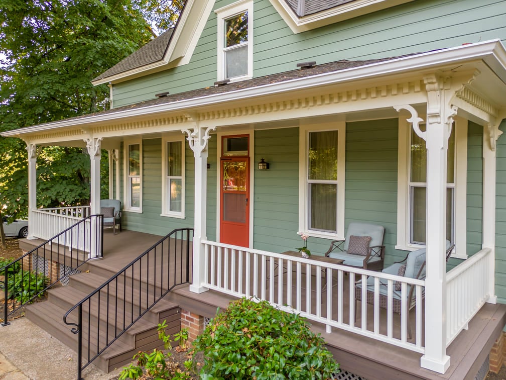 remodeled porch with white wood railing and green furniture in Salem, Oregon by Kraft Custom Construction 