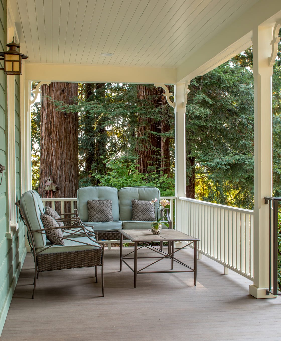 remodeled porch with white wood railing and green furniture in Salem, Oregon by Kraft Custom Construction 