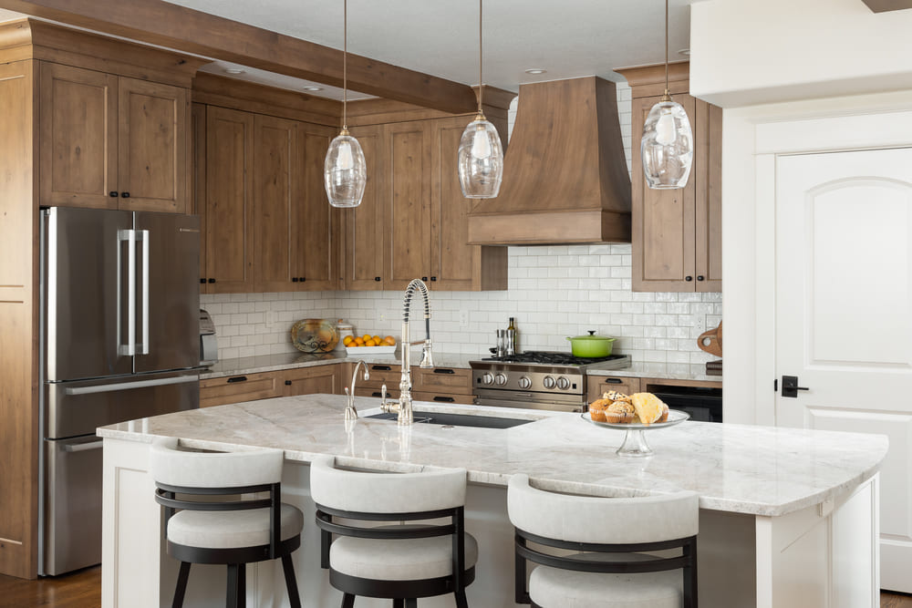 interior of French-Country Kitchen Remodel with white stools in Tualatin, Oregon by Kraft Custom Construction